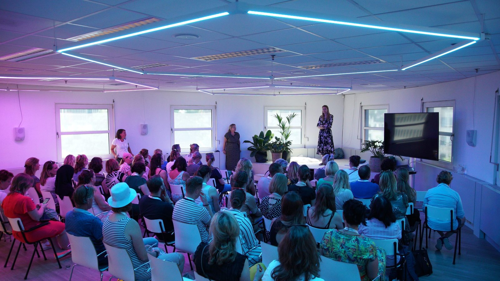 Elise de Bres standing in front of a full room