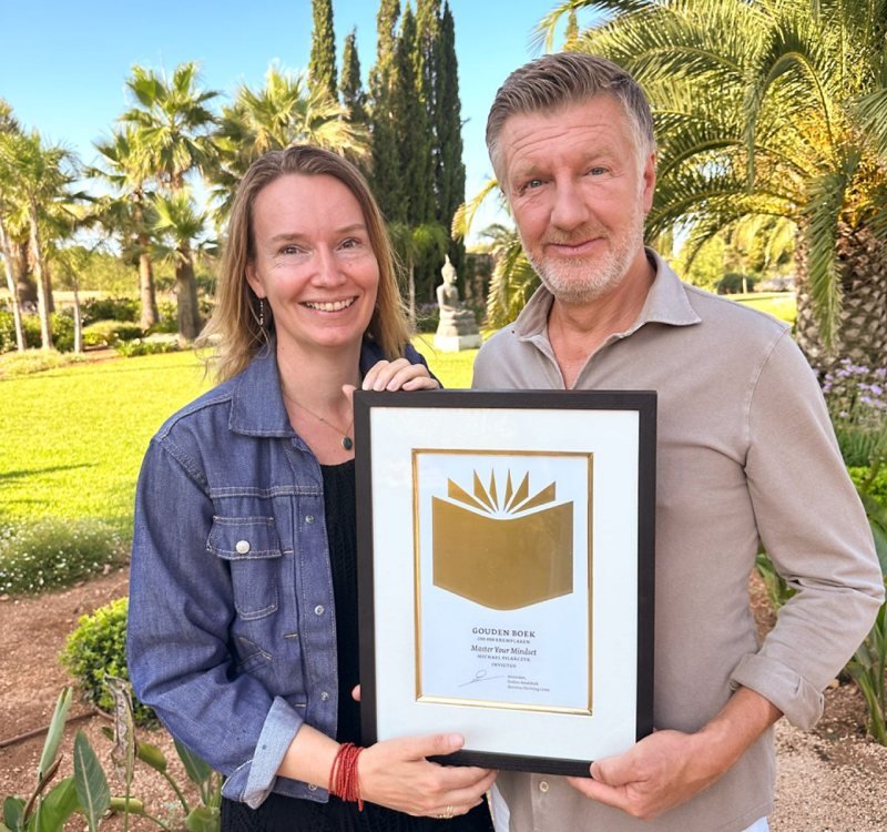 Elise de Bres and Michael Pilarczyk holding a framed Golden Book certificate